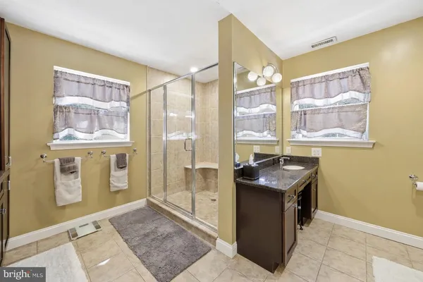 a bathroom with a granite countertop sink a mirror and a shower