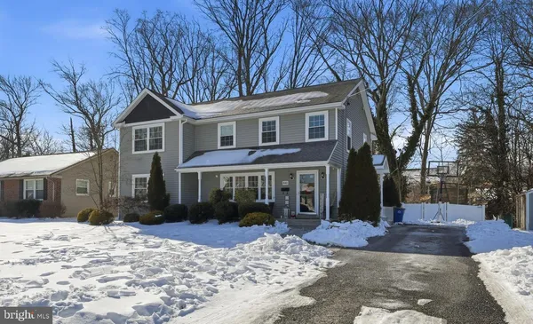 a front view of a house with a yard covered in snow