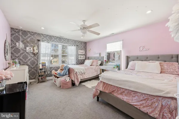 a spacious bedroom with a bed couch and window