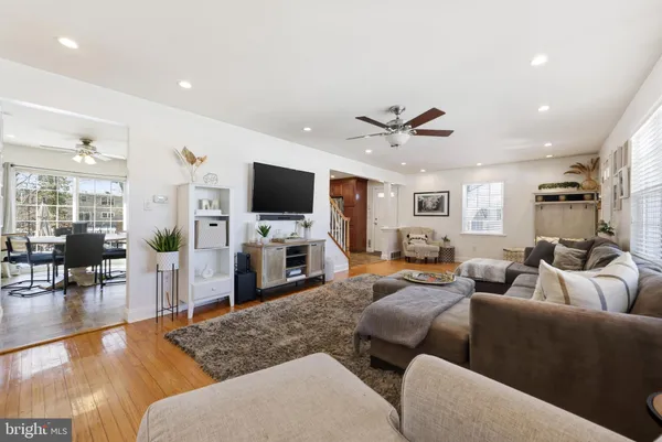 a living room with furniture and a flat screen tv with wooden floor