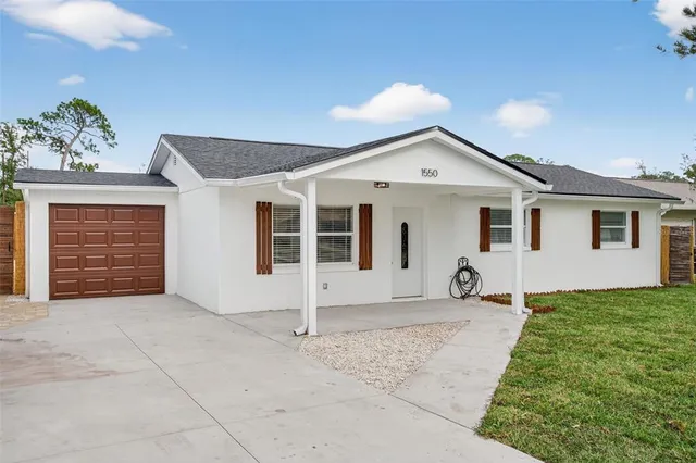 a view of a house with a yard and potted plants
