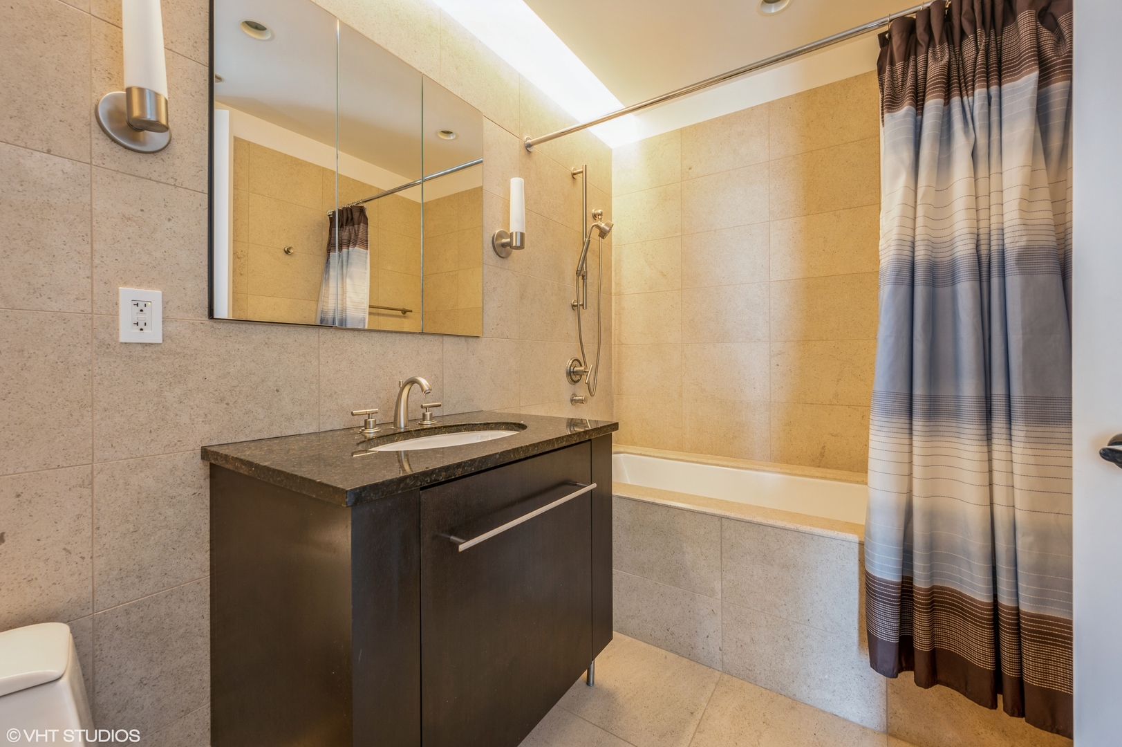 401 North Wabash Avenue, Unit 31F Chicago, IL 60611 - Photo 12 of 13 a bathroom with a granite countertop sink a mirror and a shower