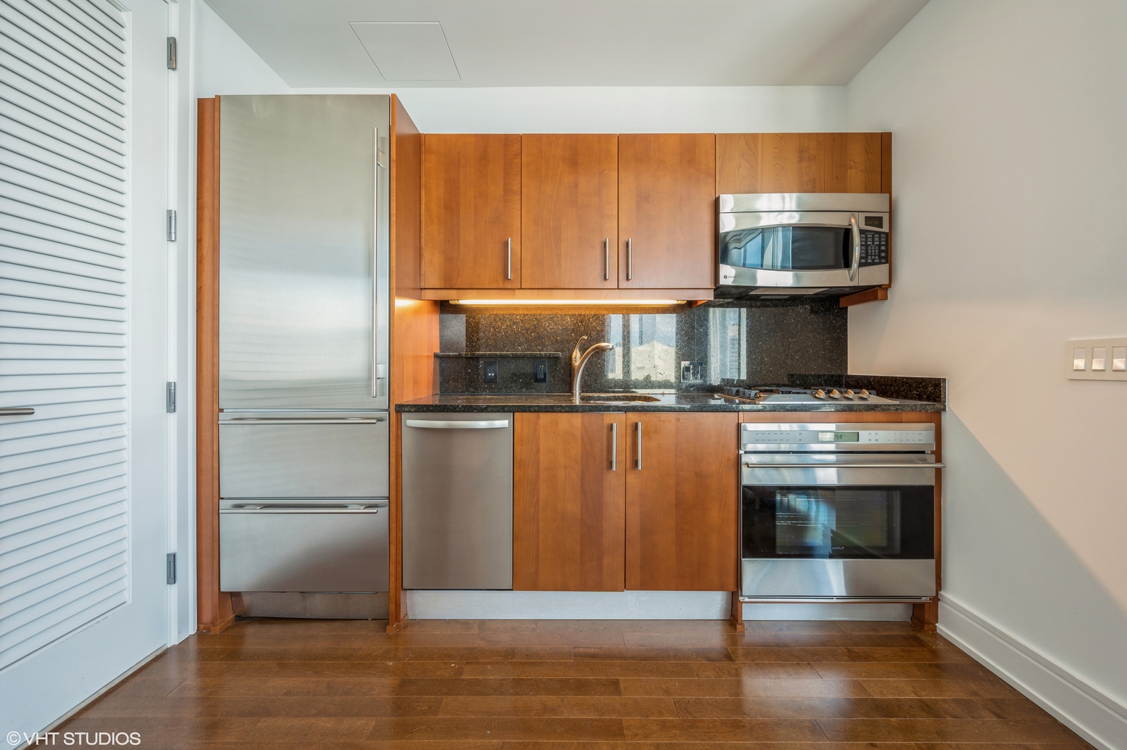 401 North Wabash Avenue, Unit 31F Chicago, IL 60611 - Photo 6 of 13 a kitchen with kitchen island a counter top space and stainless steel appliances wooden floor