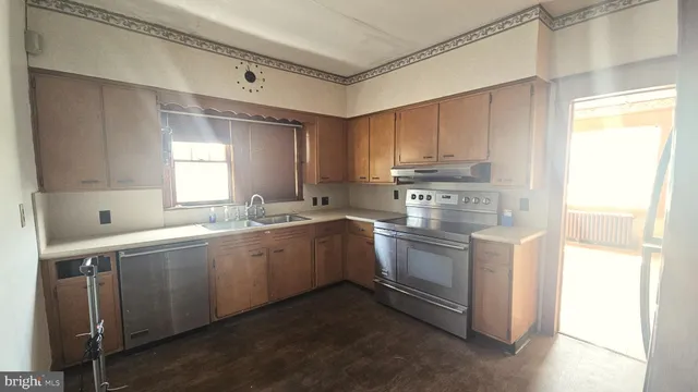 a kitchen with stainless steel appliances granite countertop a sink a stove a refrigerator and island with wooden floor