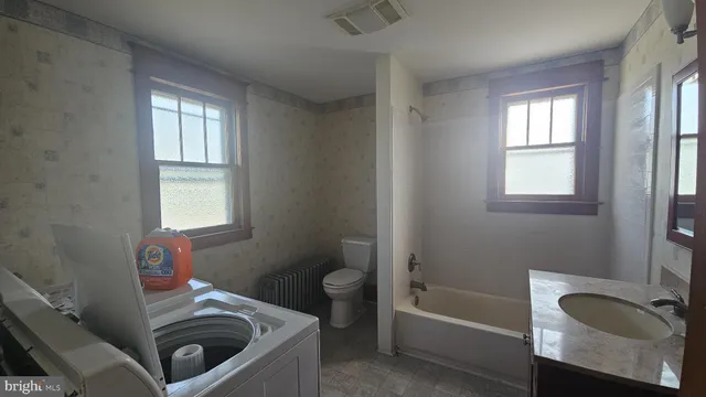 a bathroom with a tub sink toilet and mirror