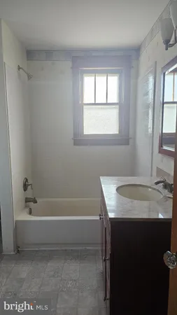 a bathroom with a granite countertop sink toilet and bathtub