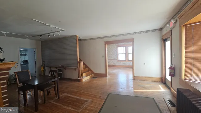 a view of a hallway with wooden floor and windows