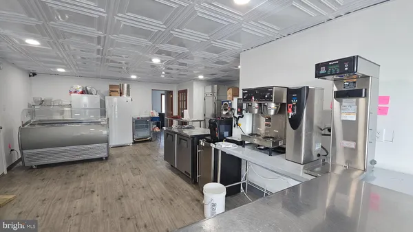 a open kitchen with refrigerator stove and wooden floor