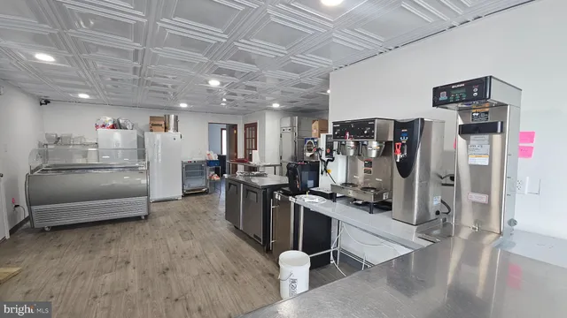 a open kitchen with refrigerator stove and wooden floor