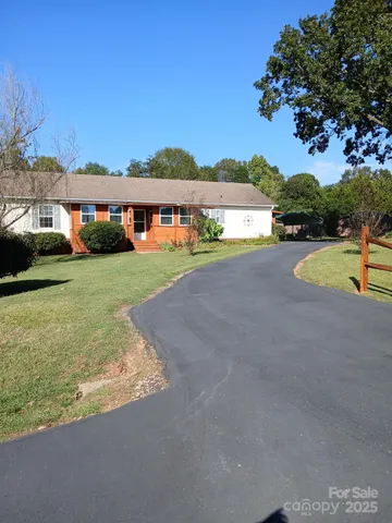 a view of a house with pool and a yard