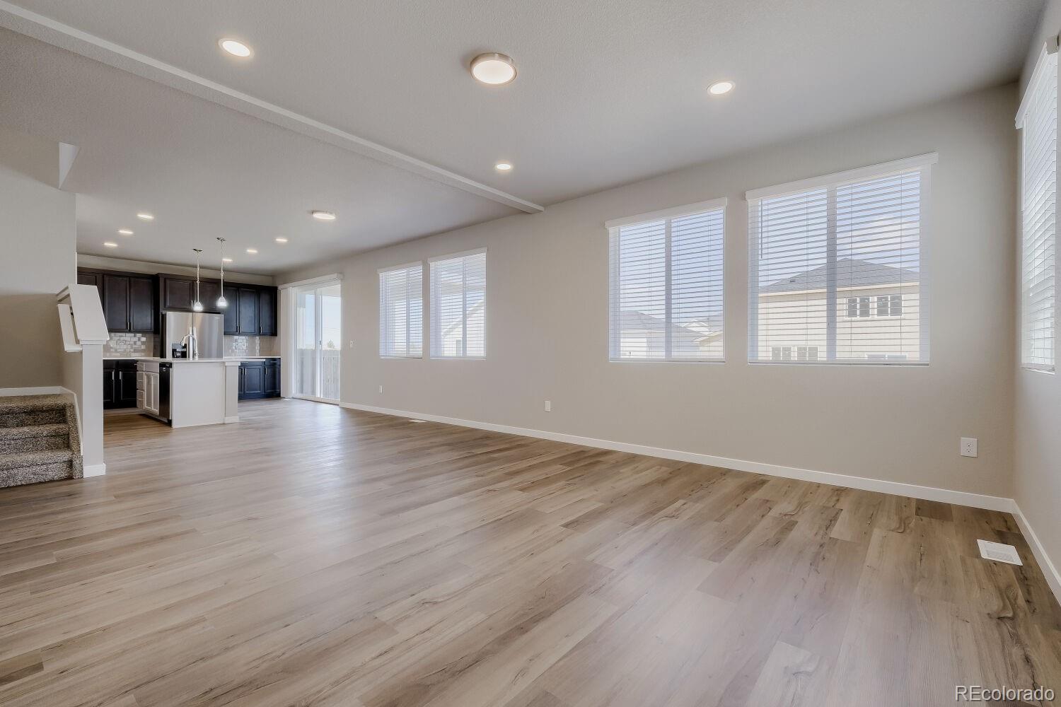 471 Atchison Way Calhan, CO 80808 - Photo 8 of 31 an empty room with wooden floor and windows