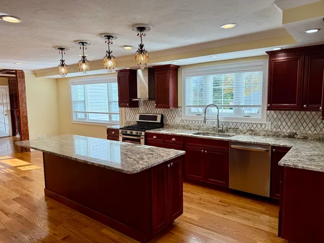 a kitchen with kitchen island granite countertop a sink window and cabinets