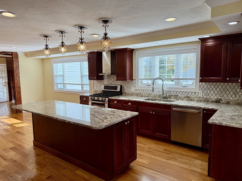 a kitchen with kitchen island granite countertop a sink window and cabinets