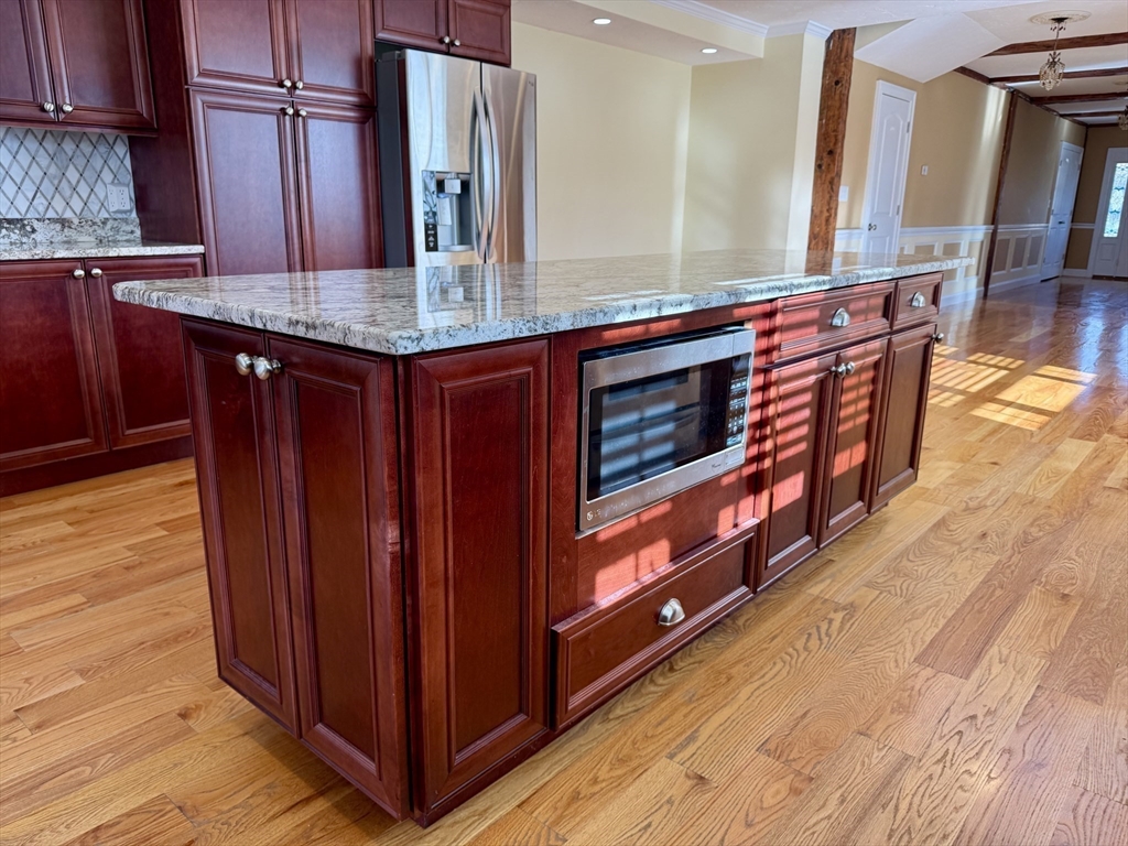 722 Lowell Street, Unit A Peabody, MA 01960 - Photo 14 of 40 a kitchen with stainless steel appliances granite countertop a stove and a wooden cabinets