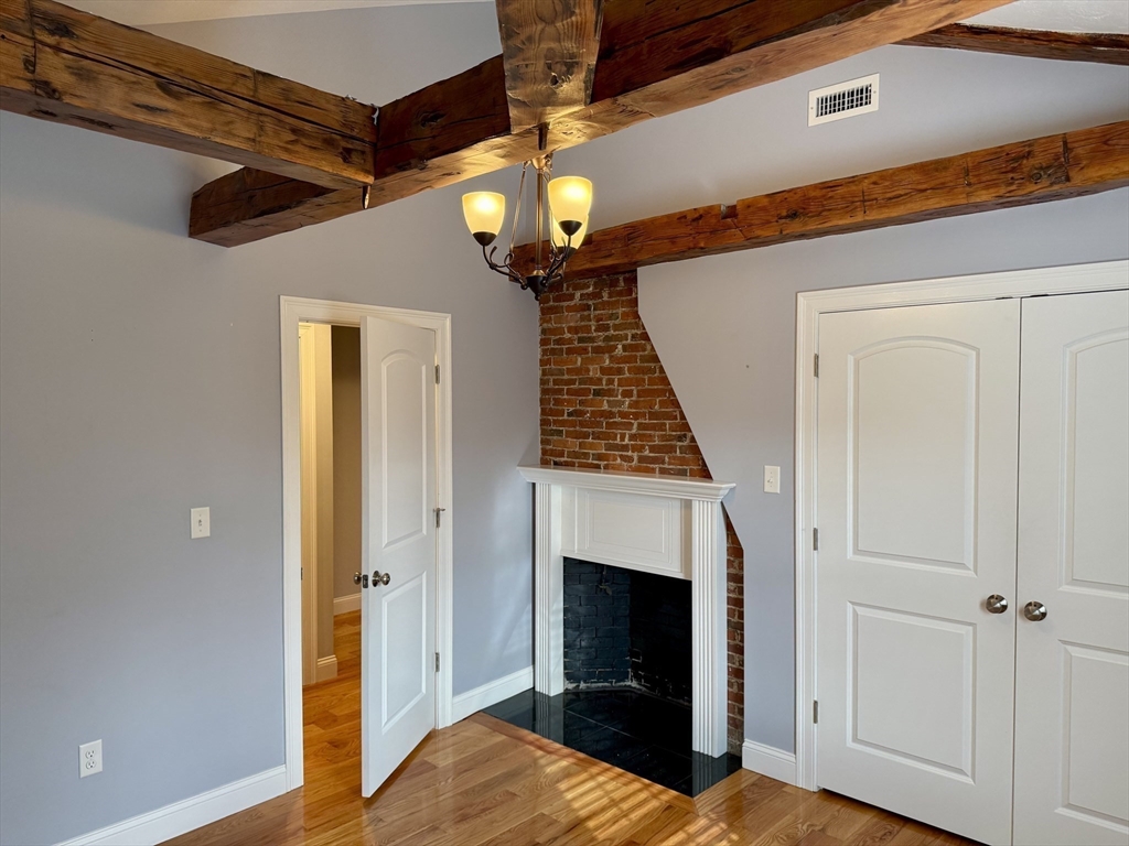 722 Lowell Street, Unit A Peabody, MA 01960 - Photo 21 of 40 a view of a livingroom with wooden floor a ceiling fan and a window