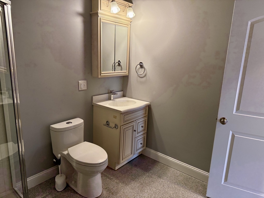 722 Lowell Street, Unit A Peabody, MA 01960 - Photo 25 of 40 a bathroom with a toilet a sink and mirror
