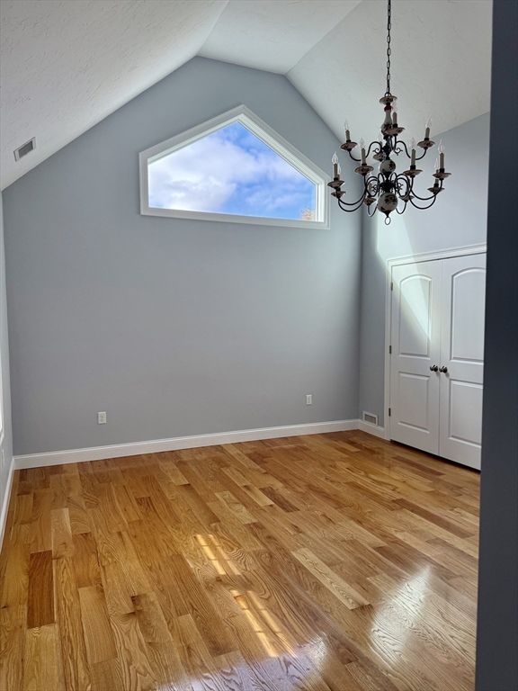722 Lowell Street, Unit A Peabody, MA 01960 - Photo 29 of 40 a view of a room with a chandelier fan and wooden floor