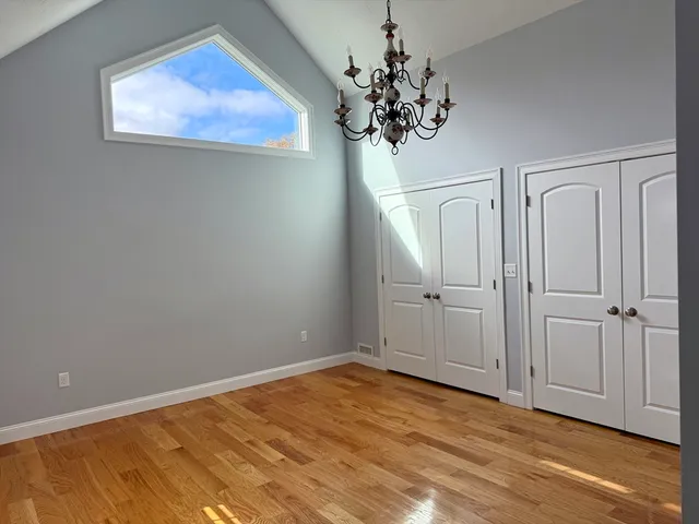 wooden floor in an empty room with a chandelier