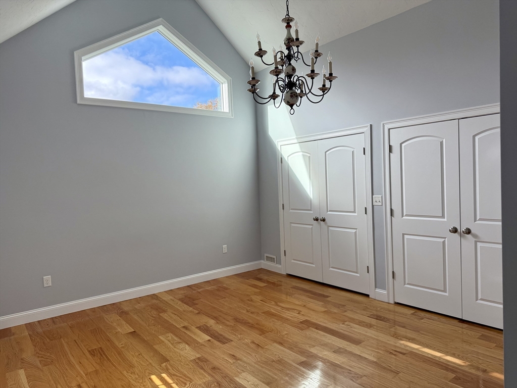 722 Lowell Street, Unit A Peabody, MA 01960 - Photo 34 of 40 wooden floor in an empty room with a chandelier