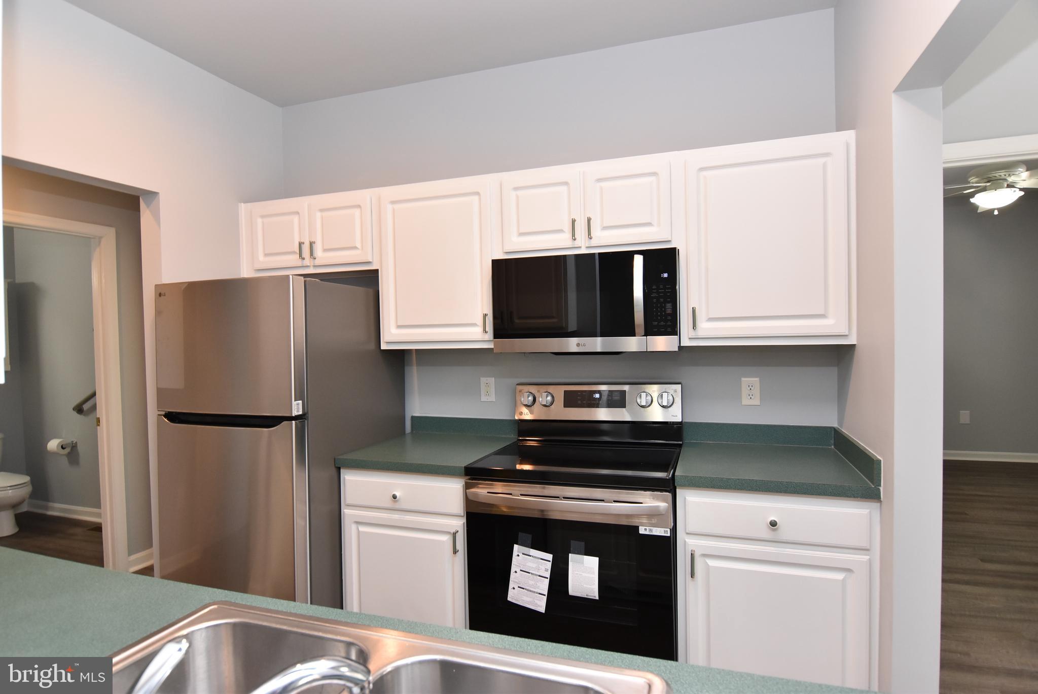 100 Cascade Lane, Unit 101 Rehoboth Beach, DE 19971 - Photo 12 of 26 a kitchen with a refrigerator stove and microwave
