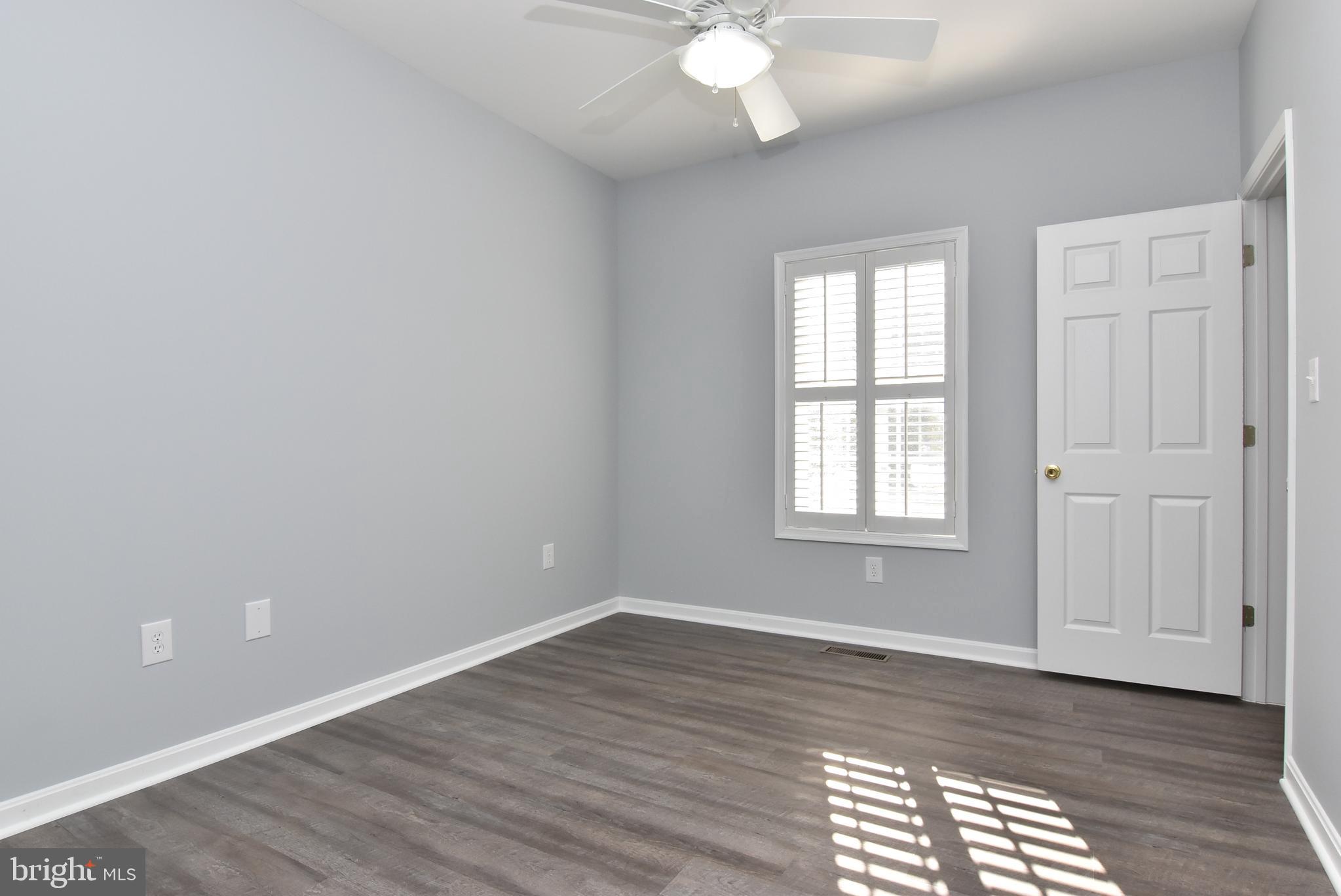100 Cascade Lane, Unit 101 Rehoboth Beach, DE 19971 - Photo 20 of 26 a view of an empty room with wooden floor and a window