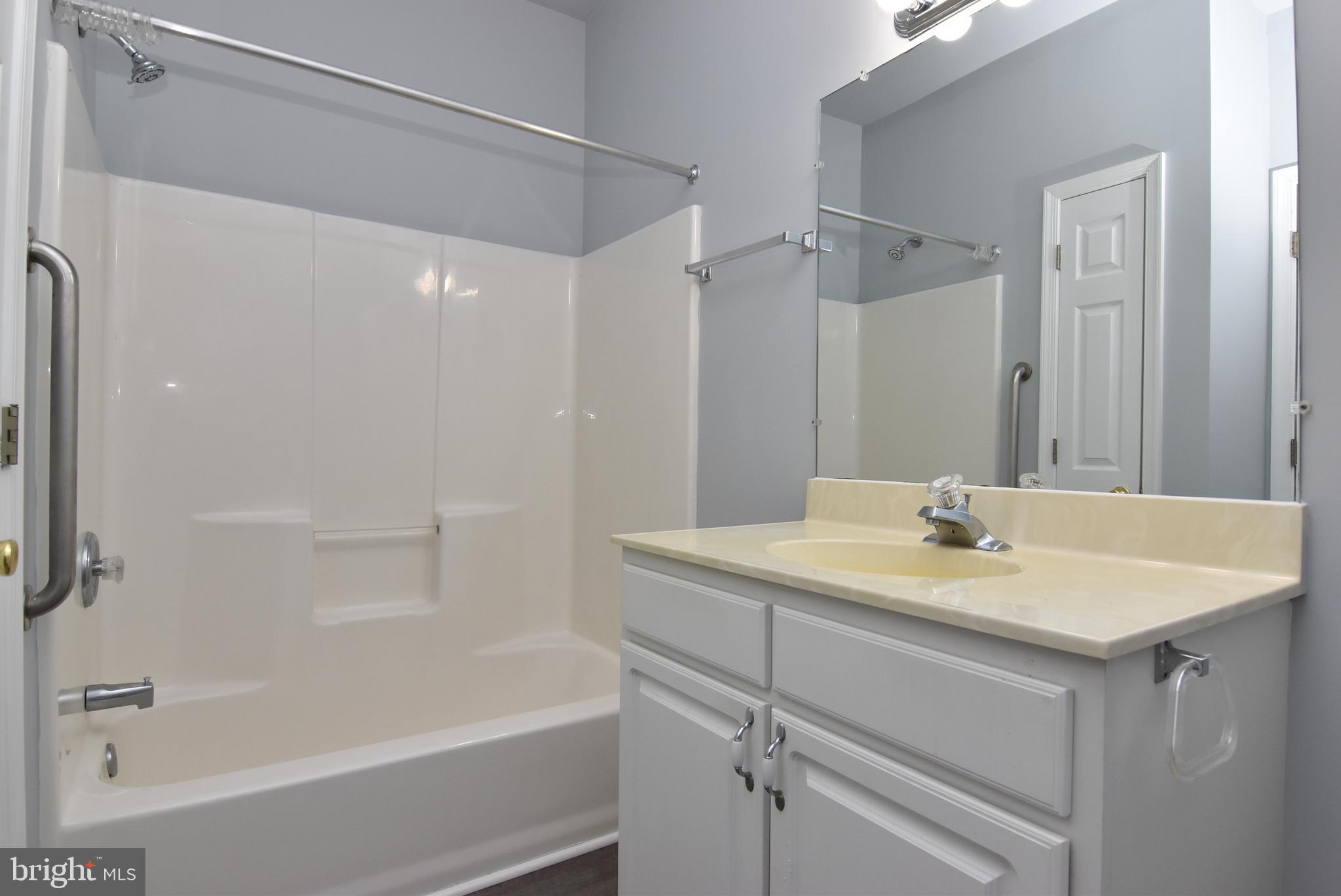100 Cascade Lane, Unit 101 Rehoboth Beach, DE 19971 - Photo 24 of 26 a bathroom with a sink a shower and a mirror