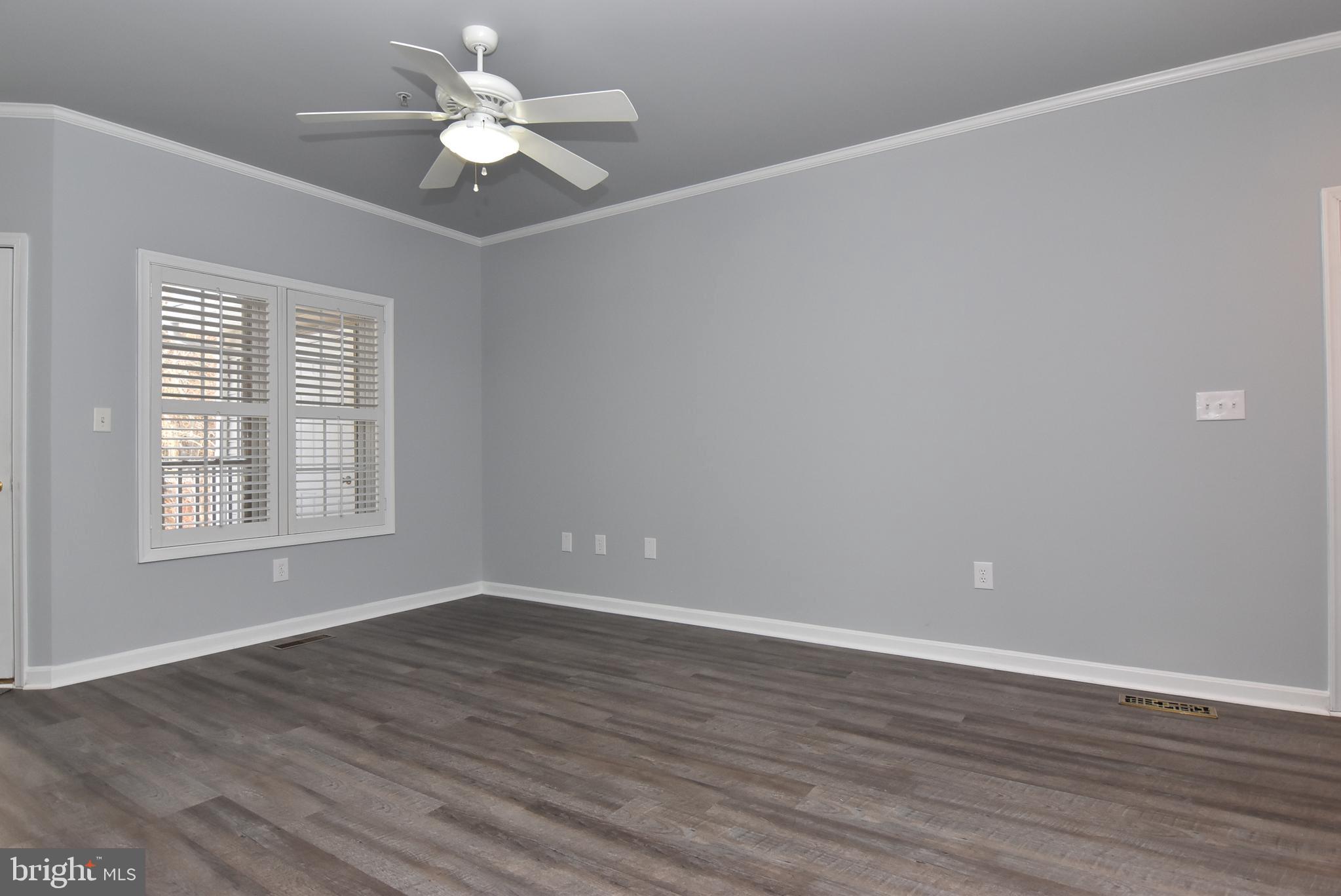 100 Cascade Lane, Unit 101 Rehoboth Beach, DE 19971 - Photo 4 of 26 wooden floor in an empty room with a window