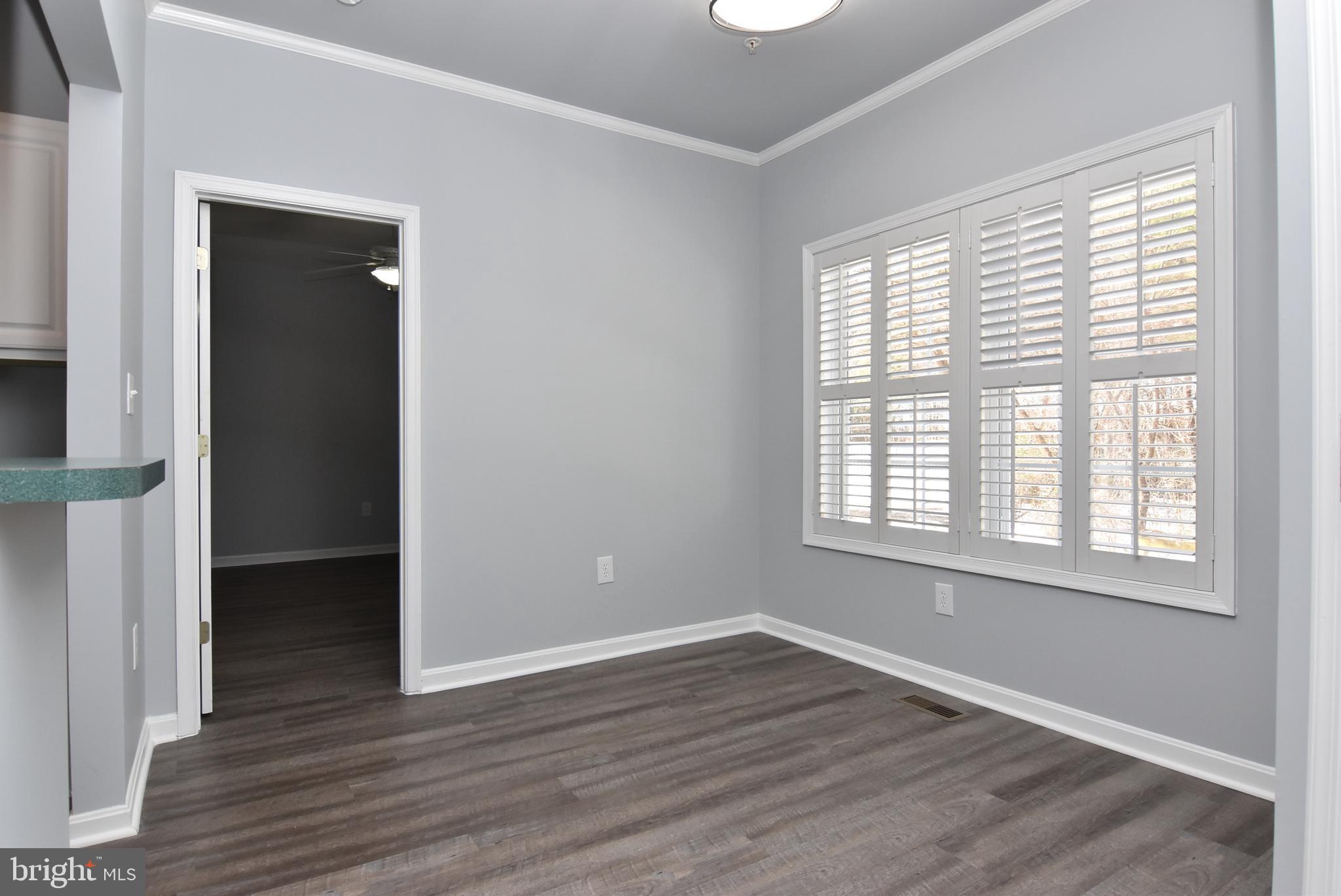 100 Cascade Lane, Unit 101 Rehoboth Beach, DE 19971 - Photo 7 of 26 an empty room with wooden floor and windows