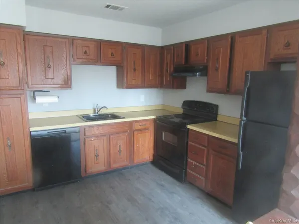 a kitchen with a sink a stove a refrigerator and cabinets