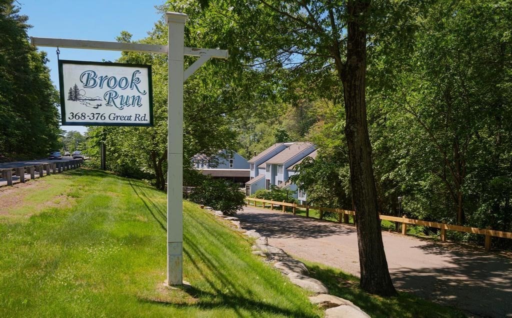 376 Great Road, Unit 15 Acton, MA 01720 - Photo 13 of 27 a view of a street with benches sitting below a tree