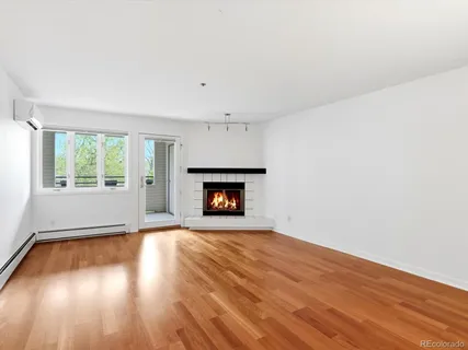 an empty room with wooden floor and fireplace