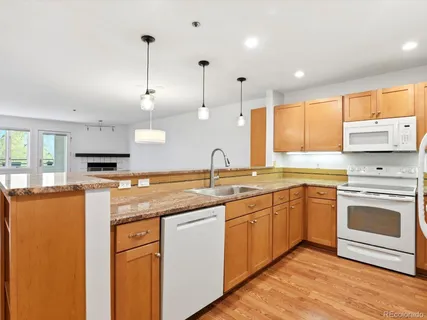a kitchen with stainless steel appliances granite countertop a sink a stove and a refrigerator