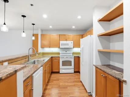 a large kitchen with stainless steel appliances granite countertop a stove sink and cabinets