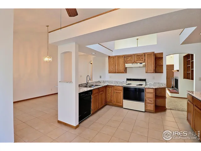 a large kitchen with stainless steel appliances kitchen island granite countertop a refrigerator and a stove top oven