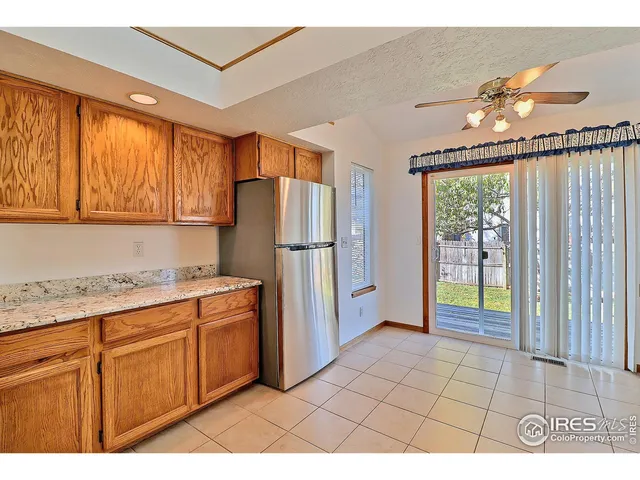 a kitchen with stainless steel appliances granite countertop a refrigerator a sink dishwasher and wooden cabinets