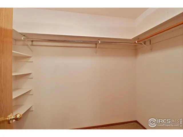 a view of an empty room with window and a ceiling fan