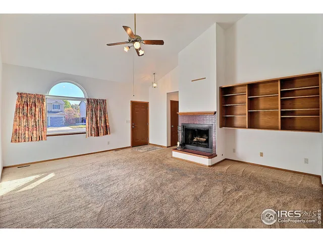 a view of an empty room with window and fireplace