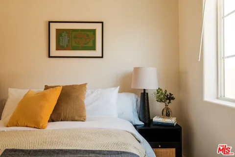 a bed sitting in a bedroom next to a lamp
