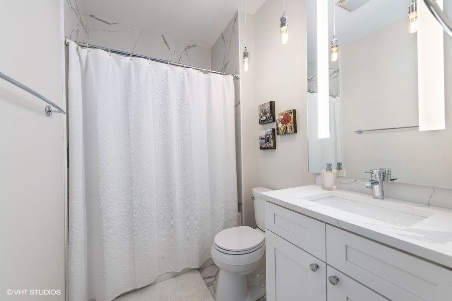 908 North Howe Street Chicago, IL 60610 - Photo 19 of 25 a bathroom with a sink a toilet and shower curtain