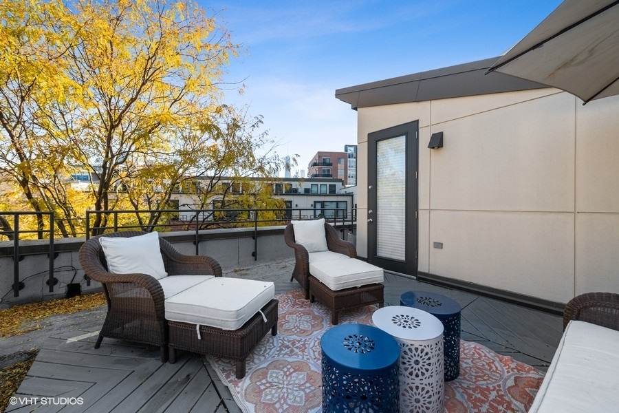 908 North Howe Street Chicago, IL 60610 - Photo 23 of 25 a view of a patio with couches table and chairs and wooden floor