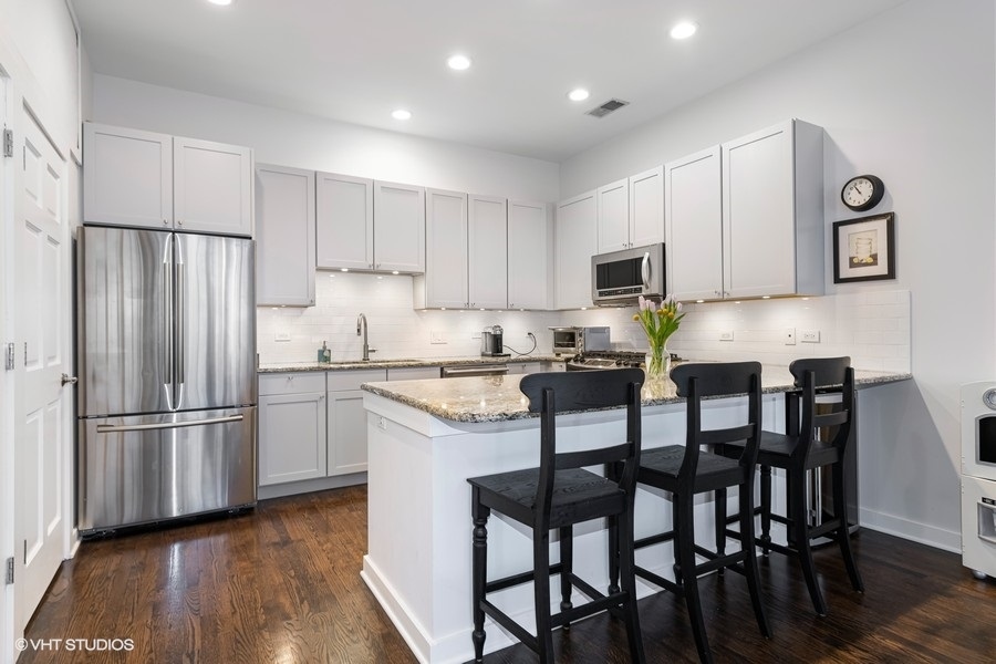 908 North Howe Street Chicago, IL 60610 - Photo 9 of 25 a kitchen with granite countertop a refrigerator and a stove top oven