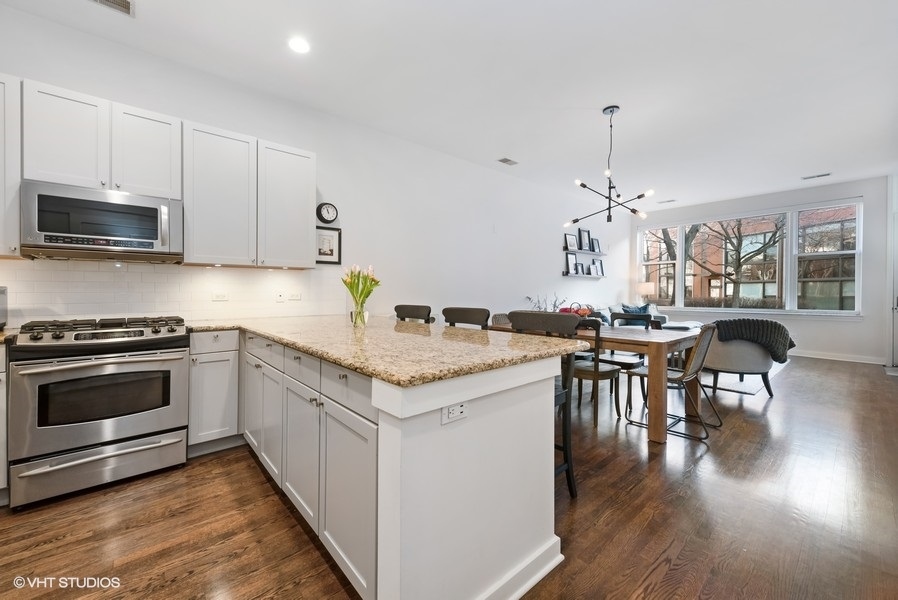 908 North Howe Street Chicago, IL 60610 - Photo 10 of 25 a kitchen with granite countertop a stove and chairs