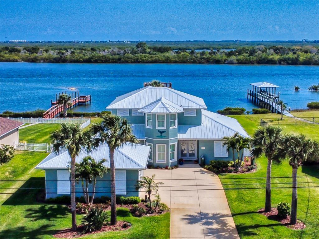 a front view of a house with a garden and lake view