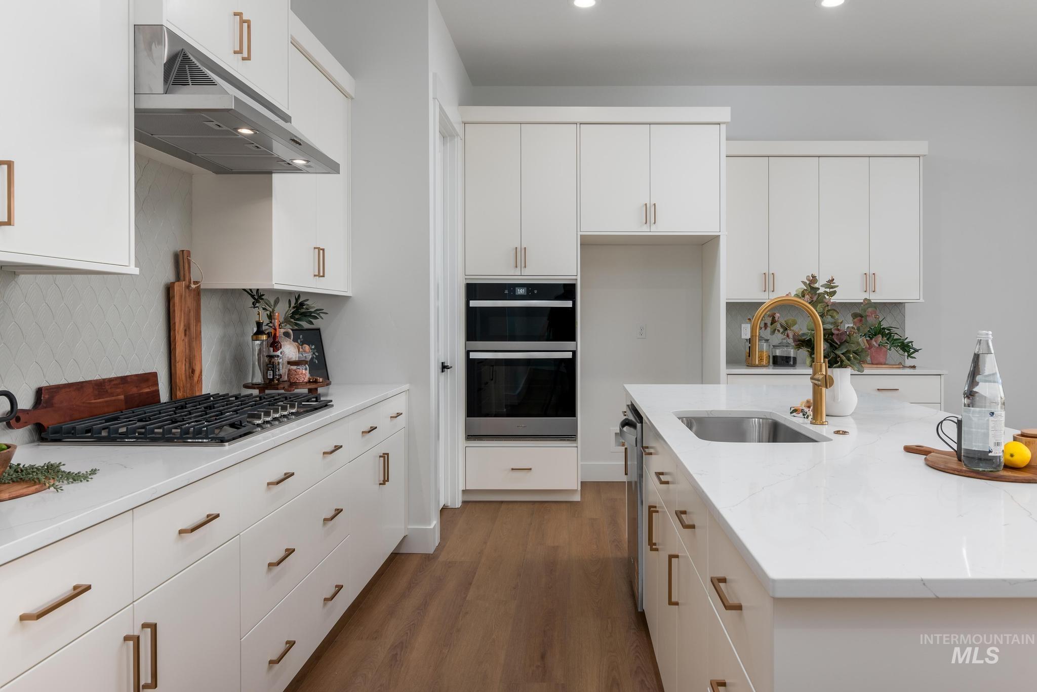 9131 West Moonglade Street Star, ID 83669 - Photo 5 of 22 Kitchen with tasteful backsplash, white cabinets, dark wood finished floors, and recessed lighting