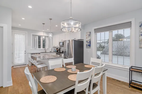 a view of a dining room with furniture a chandelier and wooden floor