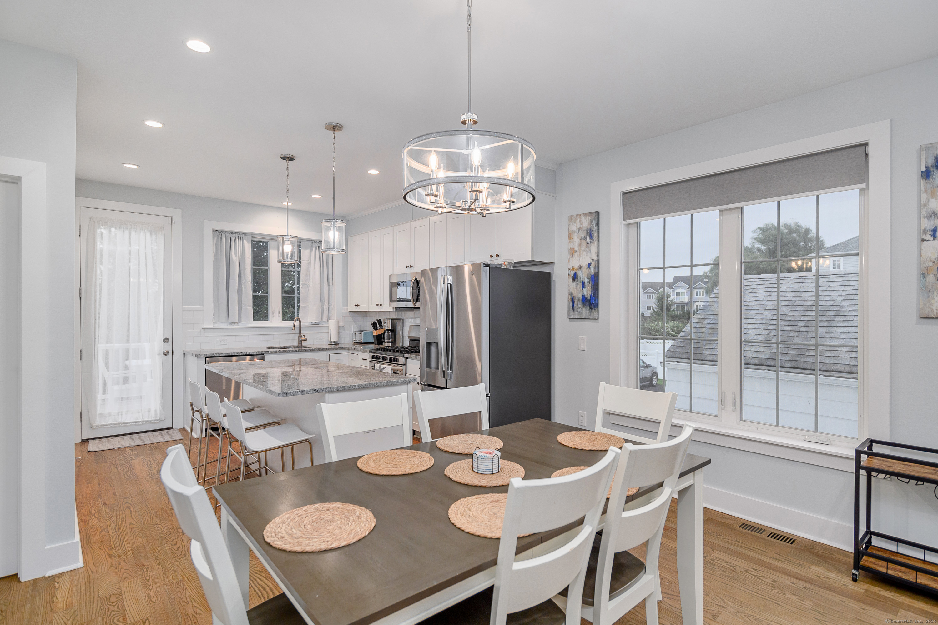 1039 Reef Road Fairfield, CT 06824 - Photo 14 of 26 a view of a dining room with furniture a chandelier and wooden floor