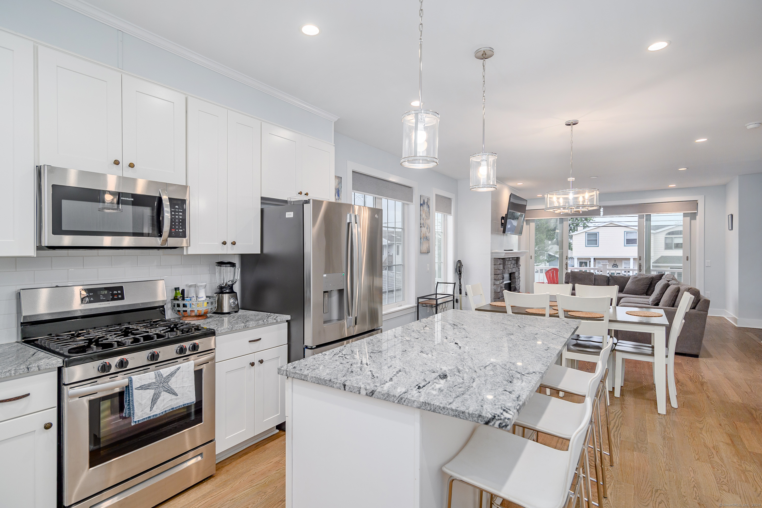 1039 Reef Road Fairfield, CT 06824 - Photo 17 of 26 a kitchen with stainless steel appliances kitchen island granite countertop a stove a refrigerator a oven a sink with a dining table and chairs