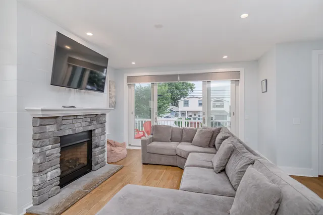 a living room with furniture a fireplace and a flat screen tv