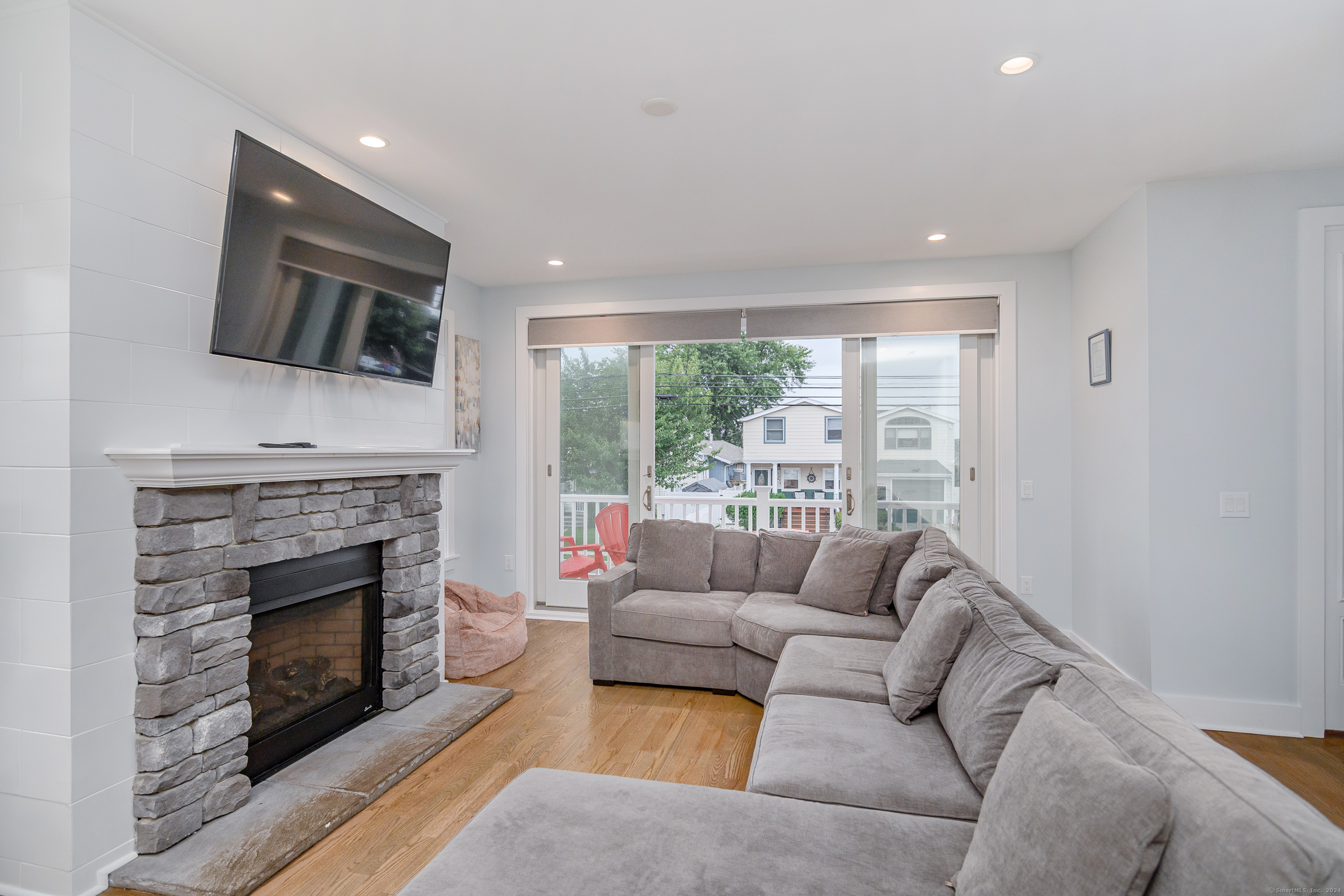 1039 Reef Road Fairfield, CT 06824 - Photo 6 of 26 a living room with furniture a fireplace and a flat screen tv
