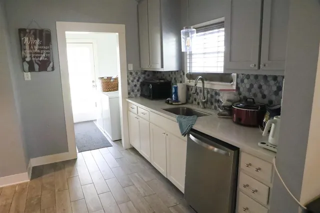 a kitchen with a sink and wooden floor